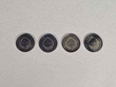 quatre types de pièces différents posés sur une surface blanche