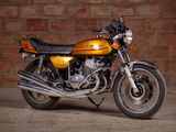 a yellow motorcycle parked in front of a brick wall