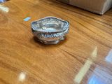 a silver plate on a wooden table with a box in the background