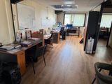 une salle où se trouvent de nombreux bureaux et chaises