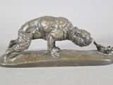 silver statue of a dog on a rock with its paw in the air