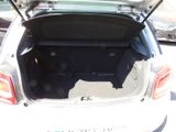 the back of a white car with its trunk open in a parking lot