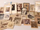 Un assortiment de vieilles photographies d'hommes et de femmes est exposé sur une table