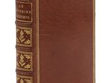 un livre en cuir marron avec des bordures dorées et des bordures dorées