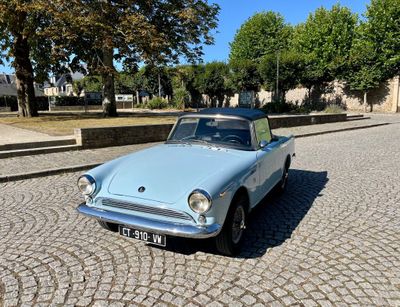 une petite voiture bleue garée dans une rue pavée
