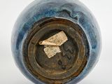 a blue vase with a piece of paper in it