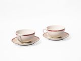 deux tasses et soucoupes sont posées sur une surface blanche