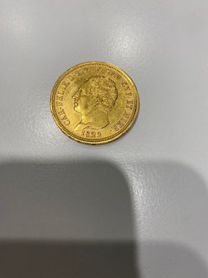 gros plan d'une pièce d'or sur une surface blanche