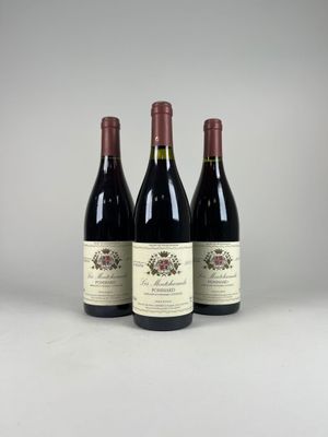 trois bouteilles de vin posées sur une table blanche
