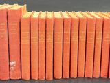 six orange books stacked on top of each other on a table