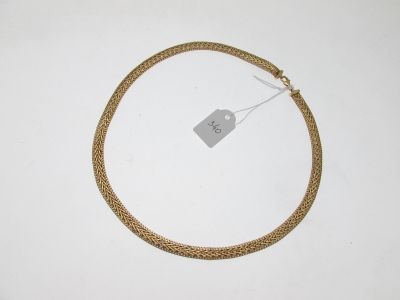 a close up of a gold necklace with a tag on it