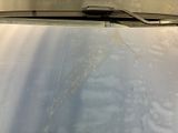 the windshield of a car that is dirty with a lot of water on it