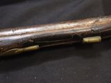 a wooden stick with a metal handle on a black cloth