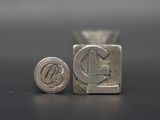 a close up of a metal stamp with the letter c on it