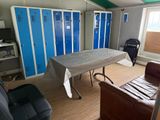 a room with a table, chairs, and lockers in it