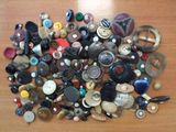 a pile of buttons on a table with a pair of scissors