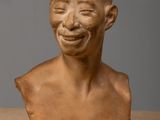 a close up of a clay bust of a man with a smile on his face