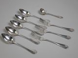 six cuillères et deux cuillères en argent sur une surface blanche