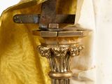 a gold cloth draped over a gold lamp on a stand