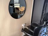 a black chair and a round mirror in a room