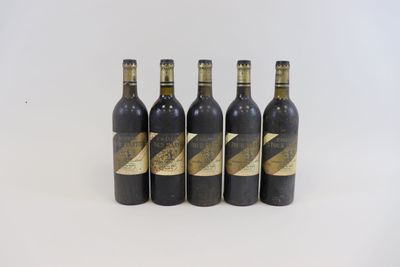 quatre bouteilles de vin sont alignées sur une surface blanche