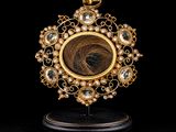 a close up of a gold locke with a stone in the center