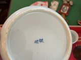 a person holding a white bowl on a table