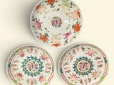 trois assiettes à motifs floraux posées sur une surface blanche