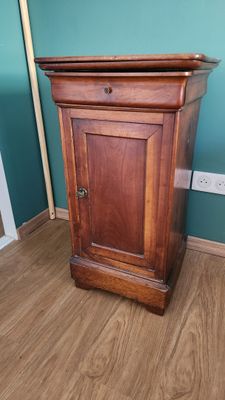 une petite armoire en bois dans un coin de la pièce