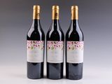 trois bouteilles de vin posées sur une table l'une à côté de l'autre