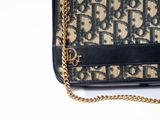 an image of a black and tan purse with a gold chain
