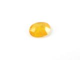 a yellow sapphire stone on a white background