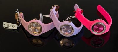 trois montres-bracelets de couleurs différentes posées les unes à côté des autres sur une surface noire