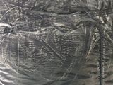 an image of a black plastic bag with a spider drawn on it