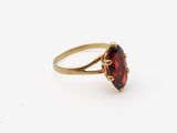 gros plan d'une bague en or avec une pierre rouge