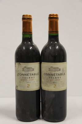 two bottles of wine sitting next to each other on a table