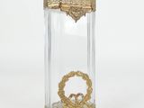 une image représentant un bocal en verre transparent orné d'un motif doré