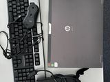 un ordinateur portable et un clavier posés sur un bureau, avec une souris à côté