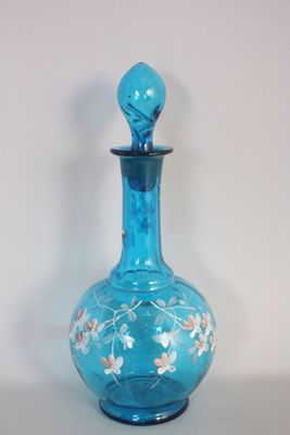 une bouteille en verre bleue ornée d'un motif floral