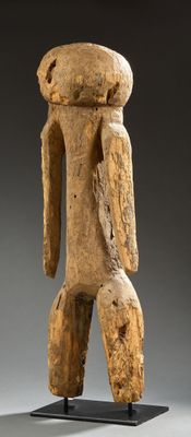 une statue en bois représentant un homme debout sur un socle noir