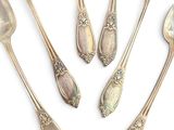 five spoons and two spoon spoons on a white surface