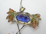 une photo d'une broche ornée d'une pierre bleue