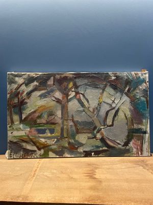 un tableau posé sur une table en bois, avec un mur bleu en arrière-plan