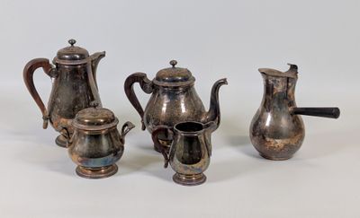 trois théières et une cafetière en argent sur une surface blanche