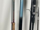 several fishing rods are lined up against a wall next to a can