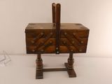 a small wooden box with a handle on a stand