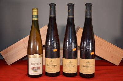 Quatre bouteilles de vin sont alignées sur une table rouge