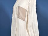 a white shirt on a mannequin stand against a blue background