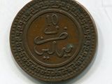 une vieille pièce de monnaie portant une inscription en arabe sur un fond blanc