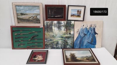 une table sur laquelle sont posées plusieurs œuvres d'art encadrées